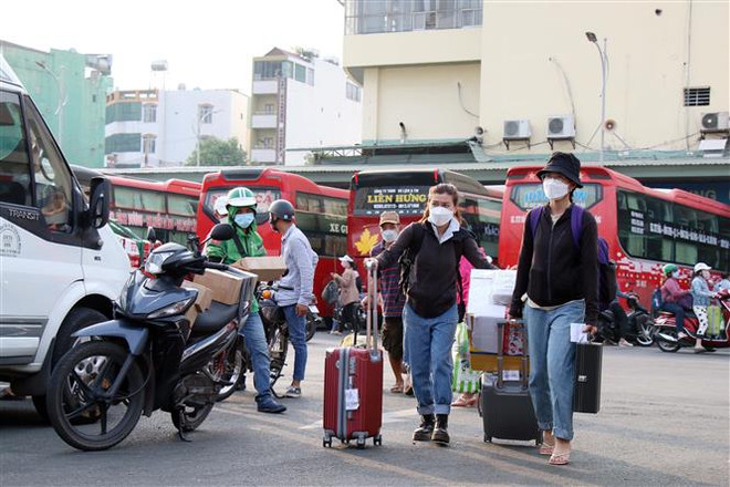 Người dân hối hả ra xe để về quê đón Tết. (Ảnh: Tiến Lực/TTXVN) Người dân TP.HCM nhộn nhịp ra bến xe, nhà ga về quê đón Tết ảnh 1