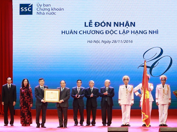 Ủy ban Chứng khoán Nhà nước đón nhận Huân chương Độc lập hạng Nhì. (Ảnh: TTXVN) Thị trường chứng khoán Việt Nam kỷ niệm 20 năm thành lập ngành ảnh 1