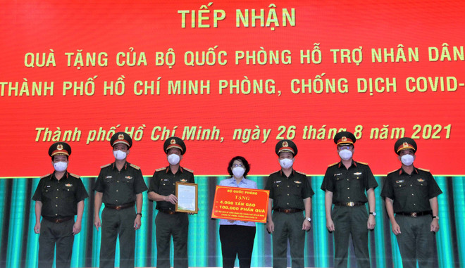 Bà Tô Thị Bích Châu, Chủ tịch Ủy ban Mặt trận Tổ quốc Việt Nam Thành phố Hồ Chí Minh tiếp nhận bảng tượng trưng quà tặng của Bộ Quốc phòng từ Trung tướng Ngô Minh Tiến. (Ảnh: TTXVN phát) Bộ Quốc phòng hỗ trợ lương thực và nhu yếu phẩm cho người dân TP.HCM ảnh 1