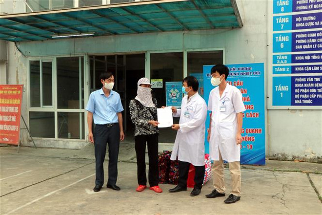Trao giấy ra viện cho bệnh nhân. (Ảnh: Mạnh Tú/TTXVN) Bệnh nhân COVID-19 cuối cùng điều trị tại Hải Dương được ra viện ảnh 1
