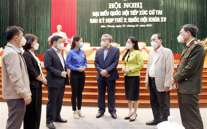 Chánh án Tòa án Nhân dân Tối cao Nguyễn Hòa Bình và đại biểu Quốc hội tỉnh Bắc Giang trao đổi với cử tri. (Ảnh: Đồng Thúy/TTXVN) Chánh án TAND Tối cao Nguyễn Hòa Bình tiếp xúc cử tri tại Bắc Giang ảnh 1