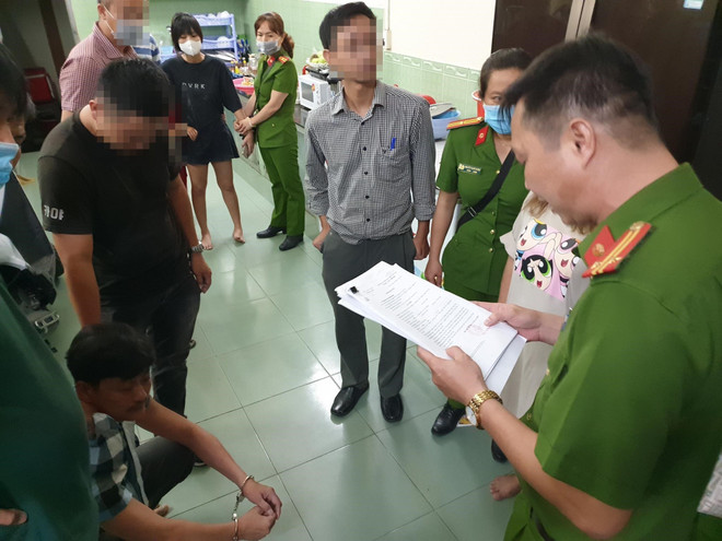Cán bộ công an đọc quyết định bắt giữ bị can, lệnh khám xét đối với Trần Công Xuân. (Ảnh: TTXVN phát) Cần Thơ: Bắt đối tượng cầm đầu vụ đốt nhà đội trưởng cảnh sát hình sự ảnh 1