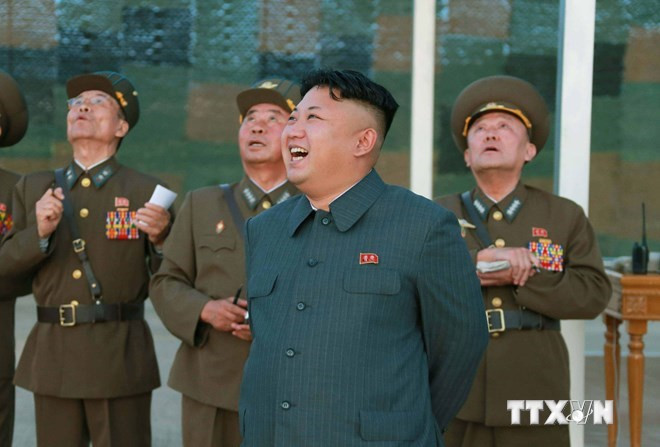 Nhà lãnh đạo Kim Jong-un (giữa) thị sát diễn tập nhảy dù của quân đội Triều Tiên tại một địa điểm bí mật ở Triều Tiên. (Nguồn: AFP/TTXVN) Ông Kim Jong-un đi thị sát và chỉ đạo đơn vị huấn luyện phi công ảnh 1