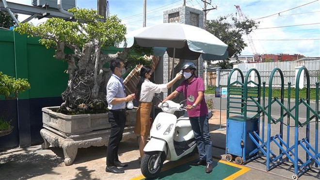Đo thân nhiệt đối với nhân viên, công nhân, khách hàng tại Công ty Cồ phần LDT (Khu công nghiệp Đông Xuyên, thành phố Vũng Tàu, tỉnh Bà Rịa-Vũng Tàu). (Ảnh: Huỳnh Sơn/TXVN) Nhiều tỉnh thành dừng các hoạt động tôn giáo đông người để phòng dịch ảnh 3