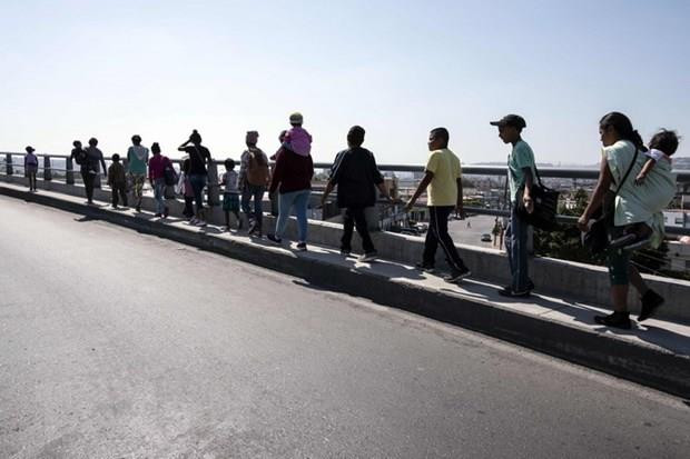 Người di cư di chuyển tới khu vực biên giới Mexico-Mỹ tại Tijuana, bang Baja California, Mexico. (Ảnh: AFP/TTXVN) Mỹ lập cơ sở dữ liệu phóng viên đưa tin về đoàn người di cư ảnh 1