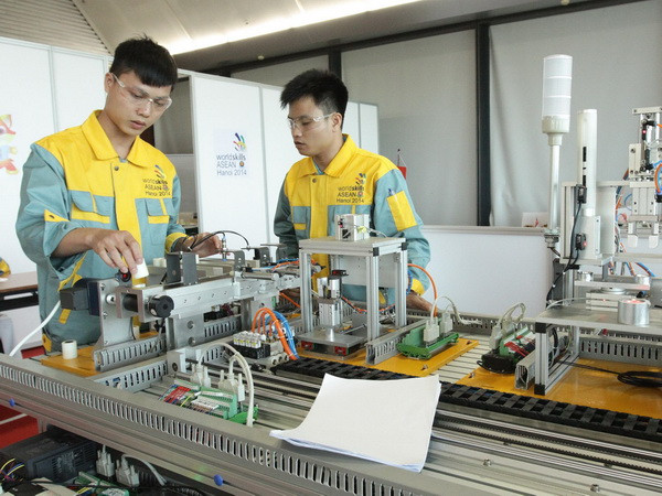 Các thi sinh thi môn Cơ điện tử đang hoàn thiện phần thi của mình. (Ảnh: Anh Tuấn/TTXVN) Thí sinh Việt Nam có nhiều tiến bộ trong Kỳ thi Tay nghề ASEAN 2014 ảnh 1
