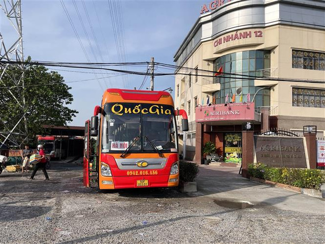 Một bãi đất trống ngay sát Bến xe An Sương (Quốc lộ 22, huyện Hóc Môn) có nhiều xe khách dừng đỗ, được “điểm mặt” là “xe dù, bến cóc”. (Ảnh: Tiến Lực/TTXVN) TP.HCM: "Xe dù, bến cóc" vẫn lấn át các bến xe chính thức ảnh 1