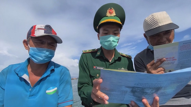 Bộ đội biên phòng Quảng Ngãi tuyên truyền vận động ngư dân cam kết tuân thủ các quy định về hoạt động khai thác thủy sản. (Ảnh: Đinh Hương/TTXVN) Go the vang IUU- quang ngai.jpg