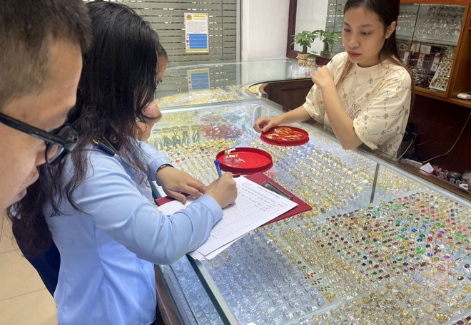 Lực lượng chức năng tỉnh Thanh Hóa kiểm tra hàng hoá vi phạm tại cơ sở kinh doanh vàng bạc Ngọc Minh. (Ảnh: TTXVN phát) kiem_tra_kinh_doanh_vang_1704-1.jpg