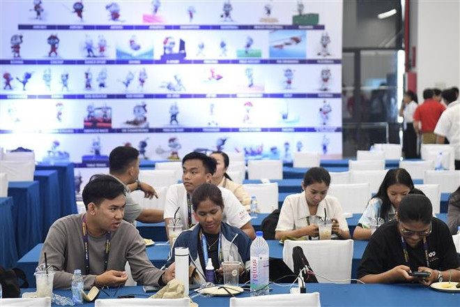 Phóng viên tác nghiệp tại Trung tâm báo chí SEA Games 32. (Ảnh: Minh Quyết/TTXVN) SEA Games 32: Nước chủ nhà Campuchia vận hành 2 trung tâm báo chí ảnh 1