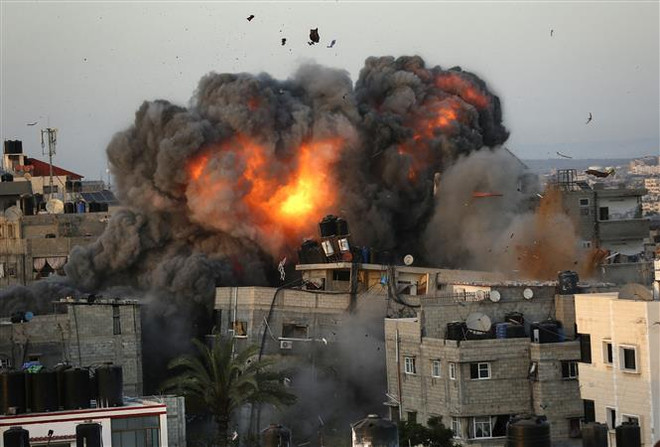Khói lửa bốc lên sau cuộc oanh kích của Isarel xuống Dải Gaza ngày 16/5/2021. (Ảnh: AFP/TTXVN) OIC họp khẩn kêu gọi quốc tế nỗ lực chấm dứt xung đột Israel-Palestine ảnh 1