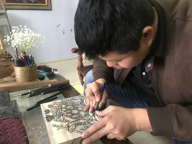 Anh Nguyễn Công Đạt, làng Thanh Liễu khắc bản gỗ với tích rùa thần nhận gươm báu ở Hồ Hoàn Kiếm. (Ảnh: Tiến Vĩnh/TTXVN) TTXVN_2902mocbanHaiDuong2.jpg