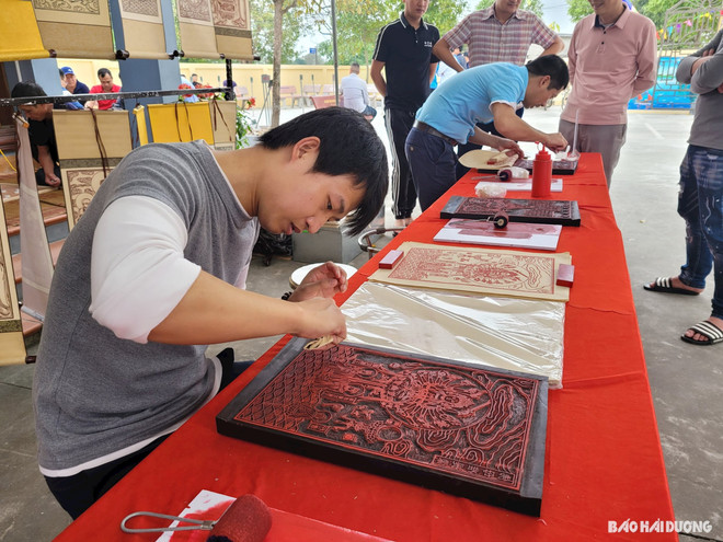 Nhiều người thích thú khi được trải nghiệm in tranh mộc bản. (Nguồn: Báo Hải Dương) 2902khacgo.jpg