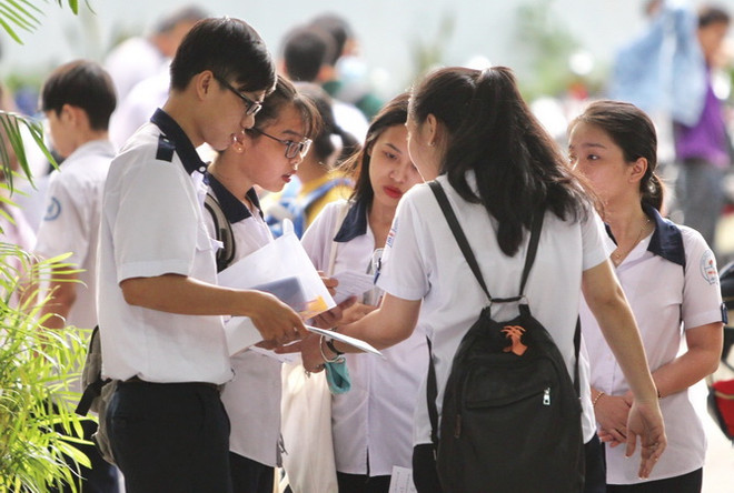 Các thí sinh trao đổi sau khi hoàn tất phần thi môn Toán tại Hội đồng thi trường THCS Collette, quận 3. TP. Hồ Chí Minh. (Ảnh: Quang Nhựt - TTXVN) Nhiều trường đại học tại TP. Hồ Chí Minh giảm điểm “sàn” xét tuyển ảnh 1