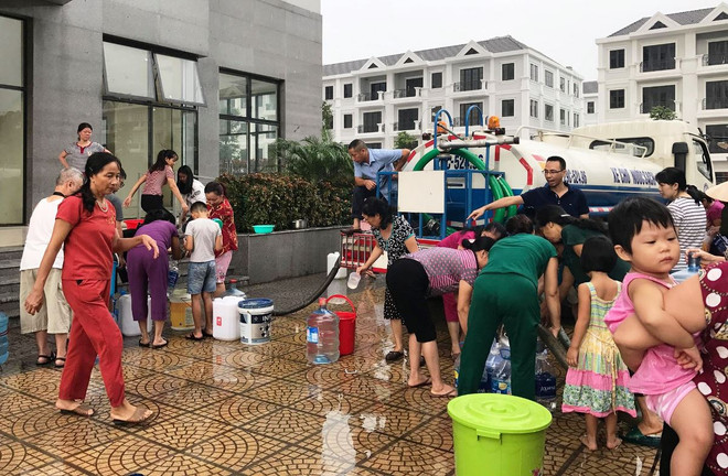 Người dân chung cư ở khu đô thị kim văn kim lũ mang can đi nhận nước sạch. (Ảnh: Hùng Võ/Vietnam+) Bộ trưởng Trần Hồng Hà: 'Cảnh báo đỏ' về an ninh nguồn nước ảnh 2