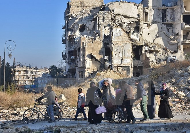 Người dân Syria sơ tán khỏi khu vực phía đông Aleppo để đến quận Bab al-Hadid - nơi quân Chính phủ giành lại quyền kiểm soát từ phiến quân, ngày 7/12. (Nguồn: AFP/TTXVN) Phiến quân Syria buộc phải để lại vũ khí hạng nặng nếu rời khỏi Aleppo ảnh 1