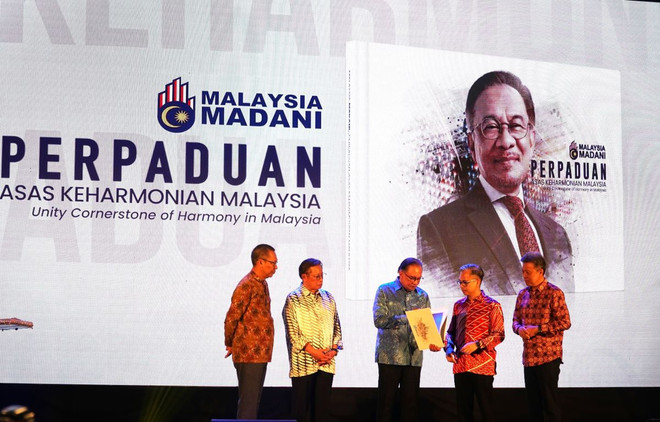Thủ tướng Anwar Ibrahim (đứng giữa) ra mắt cuốn sách 'Perpaduan Asas Keharmony Malaysia' nhân Ngày báo chí quốc gia. (Ảnh: Hằng Linh/TTXVN) ttxvn_malaysia_huong_den_mot_nen_bao_chi_chuyen_nghiep_lam_chu_cong_nghe_ai_28-2.jpg