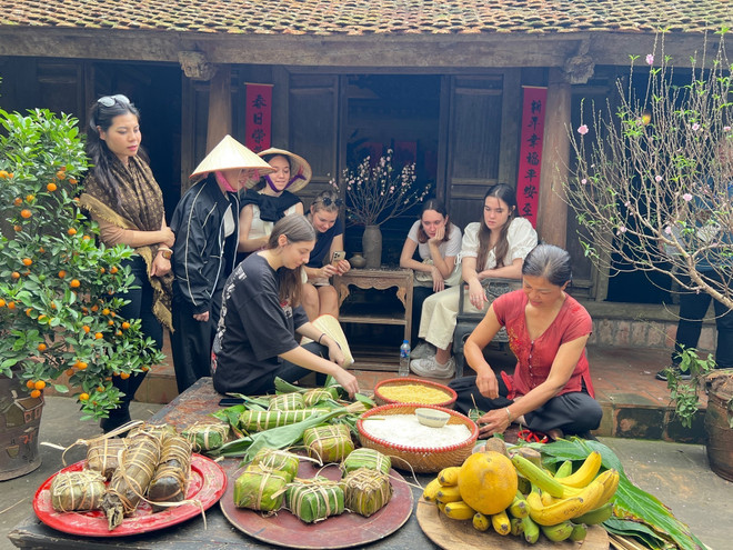 Khách quốc tế trải nghiệm gói bánh chưng tại Làng cổ Đường Lâm. (Ảnh: Đinh Thuận/TTXVN) TTXVN_0605langcoDuongLam.jpg