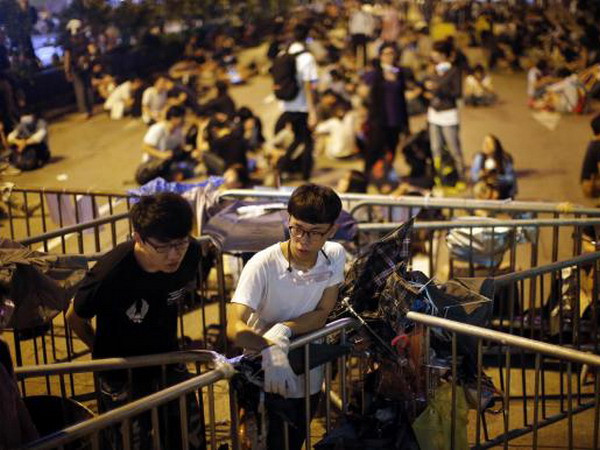 Người biểu tình đứng canh một rào chắn ở Mong Kok sau các cuộc xung đột với cảnh sát rạng sáng 18/10 (Nguồn: Reuters) Xung đột ở Mong Kok khiến tình hình Hong Kong thêm bế tắc ảnh 1