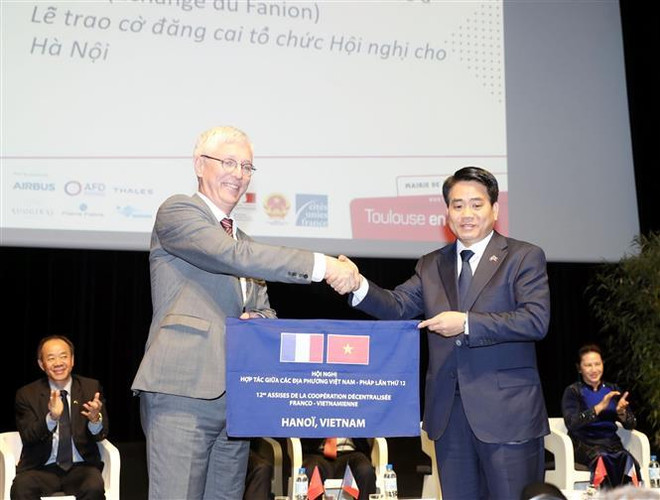 Lễ trao cờ đăng cai tổ chức Hội nghị hợp tác giữa các địa phương Việt Nam – Pháp lần thứ 12 tại Hà Nội vào năm 2022 cho Chủ tịch UBND thành phố Hà Nội Nguyễn Đức Chung. (Ảnh: Trọng Đức/TTXVN) Việt Nam-Pháp thúc đẩy hợp tác giữa các địa phương trong thời gian tới ảnh 2