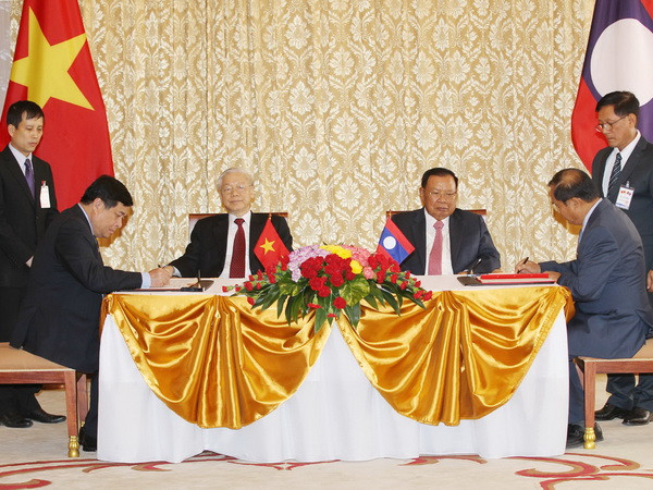 Ông Nguyễn Chí Dũng, Bộ trưởng Bộ Kế hoạch và Đầu tư, Chủ tịch Ủy ban Hợp tác Việt Nam-Lào và ông Suphan Keomisay, Ủy viên Trung ương Đảng, Bộ trưởng Bộ Kế hoạch và Đầu tư Lào ký Thỏa thuận điều chỉnh Thỏa thuận chiến lược hợp tác Việt Nam-Lào tại tỉnh Hua Phan và Xieng Khouang đến năm 2020. (Ảnh: Trí Dũng/TTXVN) Tuyên bố chung Việt Nam-Lào nhân chuyến thăm của Tổng Bí thư ảnh 1