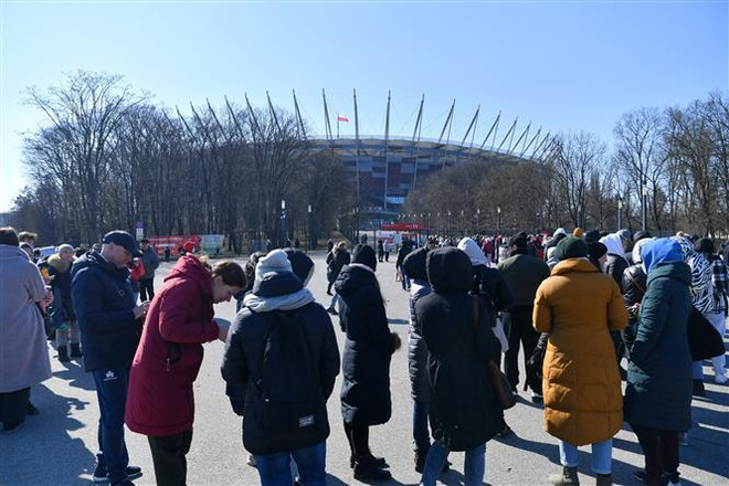 Người tị nạn từ Ukraine xếp hàng bên ngoài một điểm cấp mã số định danh tại Warsaw, Ba Lan, ngày 20/3. (Ảnh: PAP/ TTXVN) Đức đề xuất lập cầu hàng không phân bổ người Ukraine sơ tán trong EU ảnh 1