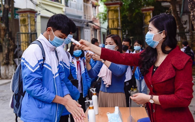 Đo thân nhiệt tại trường THCS Lý Tự Trọng, thành phố Thanh Hóa. (Ảnh: Khiếu Tư/TTXVN) Học sinh Thanh Hóa, Vĩnh Long, Cần Thơ đến trường sau nghỉ phòng dịch ảnh 1