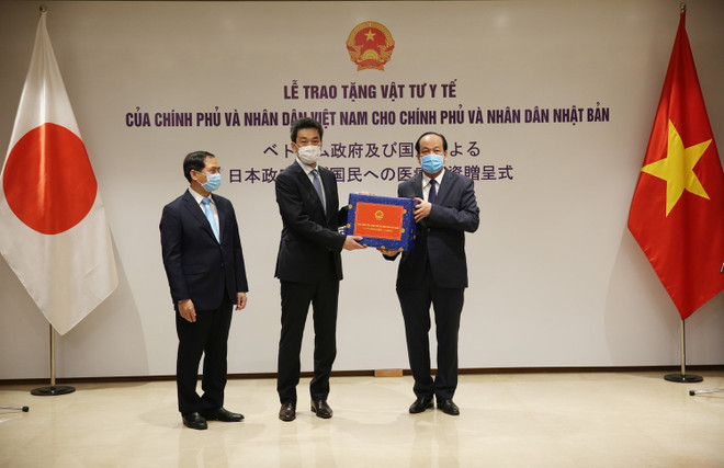Bộ trưởng, Chủ nhiệm Văn phòng Chính phủ Mai Tiến Dũng(phải) trao vật tư y tế của Chính phủ, Thủ tướng Chính phủ Nguyễn Xuân Phúc và nhân dân Việt Nam cho Phó Đại sứ Nhật Bản tại Việt Nam Shinichi Asazuma. (Ảnh: Dương Giang/TTXVN) Việt Nam tích cực hỗ trợ các quốc gia phòng, chống đại dịch COVID-19 ảnh 2