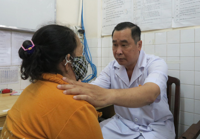 Bác sỹ Nguyễn Văn Tiến khám bệnh cho bệnh nhân trước khi nhập viện tại Khoa Ngoại 1 - Bệnh viện Ung bướu Thành phố Hồ Chí Minh. (Ảnh: Đinh Hằng/TTXVN) Bác sỹ Nguyễn Văn Tiến: "Ông Bụt áo trắng" của các bệnh nhân nghèo ảnh 4