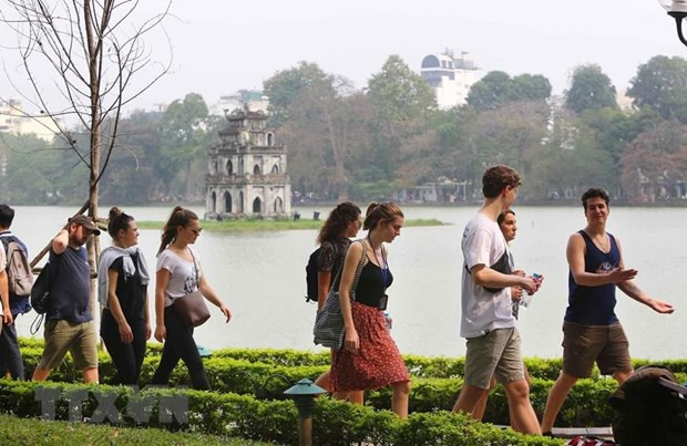 Khách du lịch nước ngoài tham quan hồ Hoàn Kiếm. (Ảnh: Thành Đạt/TTXVN) Giải đua xe Công thức 1: Cơ hội giúp du lịch Việt Nam vượt khó ảnh 2