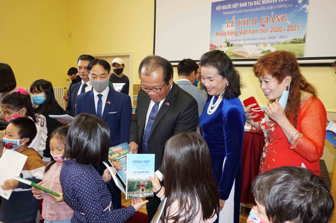 Đại sứ Thái Xuân Dũng (giữa) trao sách giáo khoa cho học sinh tại thành phố Ostrava, Bắc Morava. (Ảnh: Hồng Kỳ/Vietnam+) Nỗ lực duy trì học tiếng Việt tại vùng Bắc Morava trong bối cảnh dịch ảnh 1