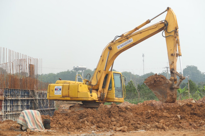Thi công đào bóc lớp đất hữu cơ làm nền đường dự án giao thông. (Ảnh: PV/Vietnam+) boc dat huu co.jpg
