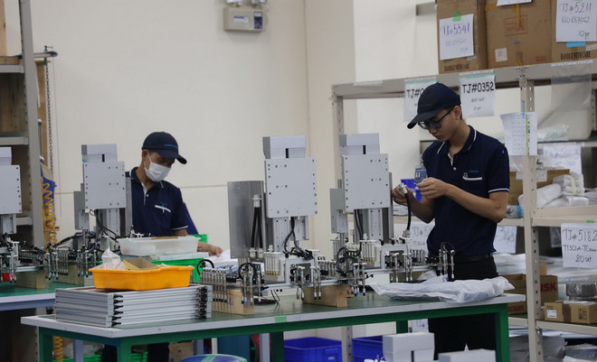 Công nhân Công ty TNHH Tazmo Việt Nam 100% vốn FDI Nhật Bản tại Khu Công nghiệp Long Hậu (Cần Giuộc) sản xuất robot công nghiệp và linh kiện tự động hóa trên các thiết bị công nghệ hiện đại. (Ảnh: Minh Hưng/TTXVN) TTXVN_1606tudonghoa.jpg