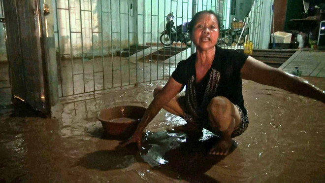 Bà Đỗ Thị Thắng, Tổ 17 phường Nguyễn Trãi, thành phố Hà Giang dọn dẹp vệ sinh sau trận mưa. (Ảnh: Nguyễn Chiến/TTXVN) Hà Giang: Nhà dân ngập bùn đất từ công trình san lấp sau mưa lớn ảnh 1