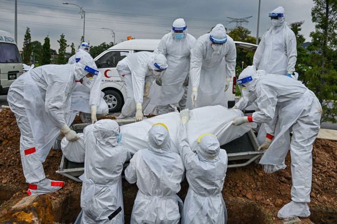 Các tình nguyện viên chôn cất thi thể bệnh nhân COVID-19 tại Kuala Lumpur, Malaysia ngày 15/6/2021. (Ảnh: AFP/TTXVN) Dịch COVID-19: Mỹ ghi nhận trường hợp đầu tiên mắc biến thể Lambda ảnh 1