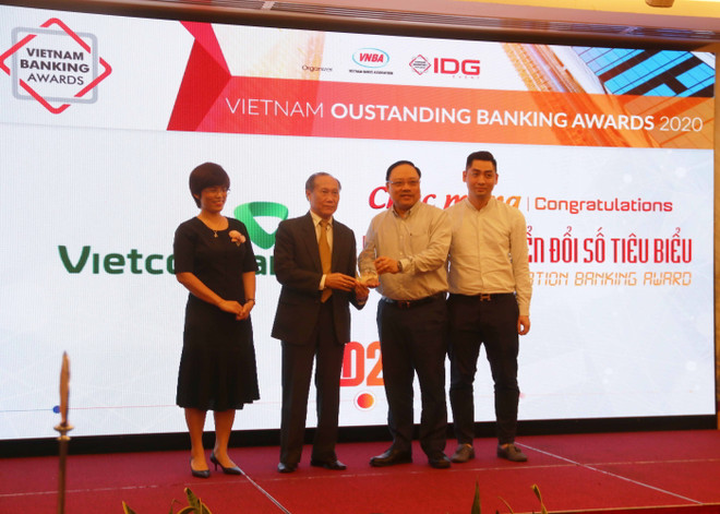 Ban Tổ chức trao giải Ngân hàng chuyển đổi số tiêu biểu 2020 cho đại diện Ngân hàng TMCP Ngoại Thương Việt Nam. (Ảnh: Hứa Chung/TTXVN) Chuyển đổi số: Vinh danh 5 ngân hàng tiêu biểu trong năm 2020 ảnh 1
