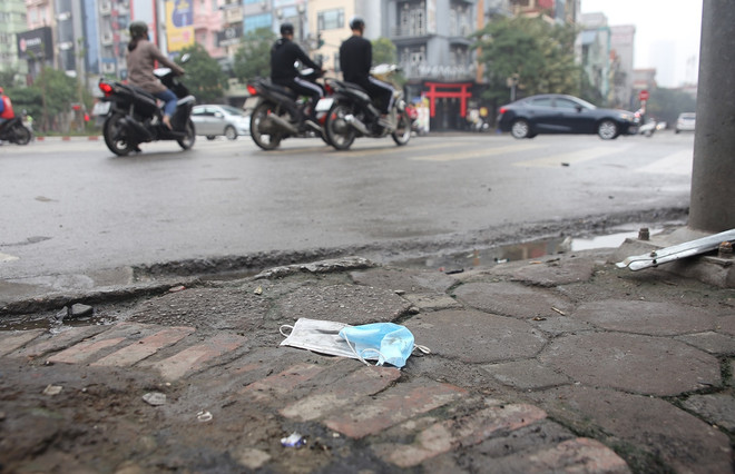 Khẩu trang y tế vương vãi ven đường. (Ảnh: PV/Vietnam+) Vứt khẩu trang ra vỉa hè, đường phố có thể bị phạt đến 7 triệu đồng ảnh 10