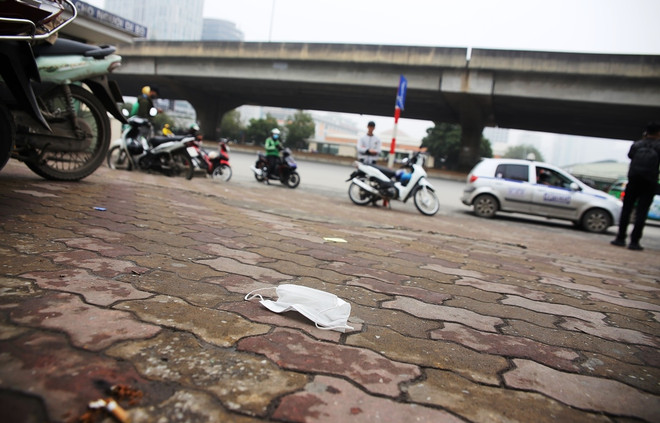 Khẩu trang y tế vương vãi trên vỉa hè. (Ảnh: PV/Vietnam+) Vứt khẩu trang ra vỉa hè, đường phố có thể bị phạt đến 7 triệu đồng ảnh 3