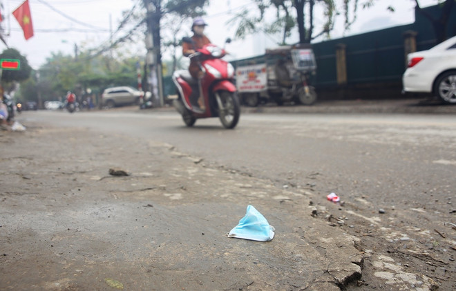 Khẩu trang y tế vương vãi ven đường. (Ảnh: PV/Vietnam+) Vứt khẩu trang ra vỉa hè, đường phố có thể bị phạt đến 7 triệu đồng ảnh 8