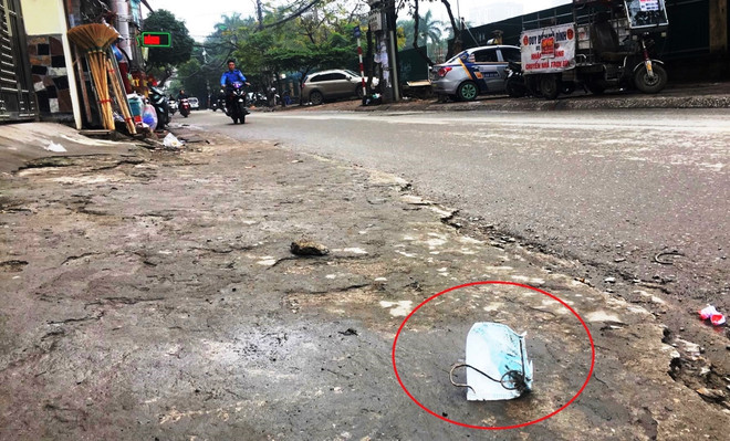 Khẩu trang y tế vương vãi bên vỉa hè. (Ảnh: PV/Vietnam+) Vứt khẩu trang ra vỉa hè, đường phố có thể bị phạt đến 7 triệu đồng ảnh 4