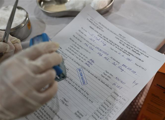 Đóng dấu cấp giấy chứng nhận đã tiêm vaccine phòng dịch COVID-19 cho người lao động. (Ảnh: Danh Lam/TTXVN) Ngày 16/9: Gần 60.000 ca COVID-19 khỏi bệnh, không có ca tử vong ảnh 1