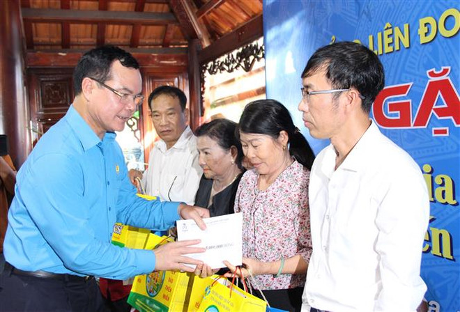 Đồng chí Nguyễn Đình Khang, Chủ tịch Tổng liên đoàn Lao động Việt Nam trao quà và 5 triệu tiền mặt cho thân nhân các liệt sỹ đã hy sinh tại trận chiến đấu bảo vệ đảo Gạc Ma tại huyện Cam Lâm. (Ảnh: Phan Sáu/TTXVN) Các hoạt động nhân kỷ niệm 75 năm ngày thương binh liệt sỹ ảnh 4