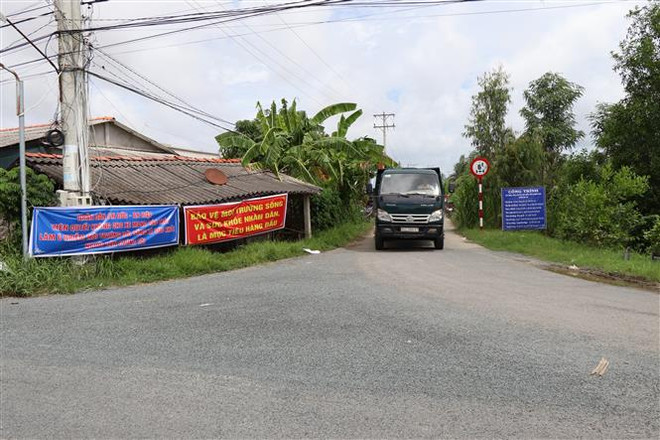 Người dân hai xã An Hiệp, An Đức, huyện Ba Tri lập chốt chặn các xe vận chuyển rác. (Ảnh: Công Trí/TTXVN) Bến Tre: Công bố tình huống khẩn cấp về môi trường tại bãi rác An Hiệp ảnh 2
