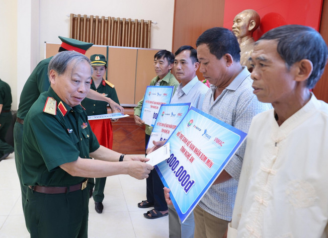 Trung tướng Phạm Ngọc Khóa, Phó Chủ tịch thường trực Hội hỗ trợ khắc phục hậu quả bom mìn Việt Nam trao hỗ trợ sinh kế cho các nạn nhân bom mìn huyện Nam Đàn. (Ảnh: Lâm Khánh/Vietnam+) vnp_2806nannhanbommin2.jpg