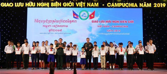 Trung tướng Hoàng Xuân Chiến, Tư lệnh Bộ đội Biên phòng Việt Nam (hàng đầu thứ 7 trái qua) và Đại tướng Hun Manet, Phó Tổng tư lệnh, kiêm Tư lệnh Lục quân Quân đội Hoàng gia Campuchia tặng học bổng cho 30 em học sinh của ba tỉnh An Giang (Việt Nam), Takeo và Kanđal (Campuchia). (Ảnh: Công Mạo/TTXVN) Tọa đàm giao lưu hữu nghị biên giới Việt Nam-Campuchia ảnh 2