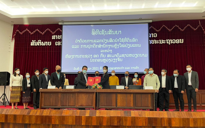 Đại diện Bộ Công Thương Lào và Hội người Việt Nam thủ đô Vientiane thực hiện ký kết thỏa thuận. (Nguồn: tapchilaoviet.org) Bộ Công Thương Lào chuyển quyền sử dụng đất công cho chùa Phật Tích ảnh 1