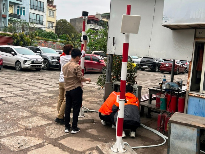 Nhân viên lắp đặt hệ thống thiết bị vận hành ứng dụng trông giữ xe thông minh tại phố Trần Quang Khải, thành phố Hà Nội. (Ảnh: Việt Hùng/Vietnam+) vnp_lap thiet bi trong giu xe.jpg