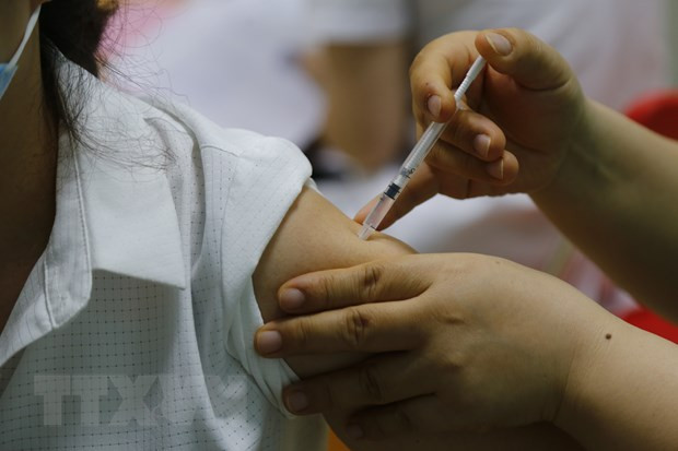 Nhân viên y tế tiêm vaccine cho người dân. (Ảnh: Nam Sương/TTXVN) Ngành y tế Thành phố Hồ Chí Minh đối mặt với nhiều nguy cơ, thách thức ảnh 2