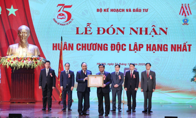 Thủ tướng Nguyễn Xuân Phúc, Chủ tịch Hội đồng Thi đua-Khen thưởng Trung ương tặng Huân chương Lao động hạng Nhất cho Bộ trưởng Bộ Kế hoạch và Đầu tư Nguyễn Chí Dũng. (Ảnh: Danh Lam/TTXVN) Thủ tướng: Thúc đẩy hơn nữa tinh thần khởi nghiệp, đổi mới sáng tạo ảnh 2