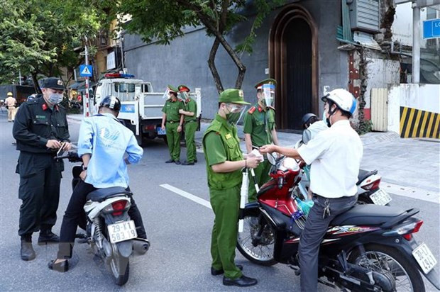 Lực lượng Công an Hà Nội kiểm tra giấy tờ của người tham gia giao thông tại chốt liên ngành tuyến phố Trần Quang Khải (quận Hoàn Kiếm). (Ảnh: Phạm Kiên/TTXVN) Hà Nội tháo dỡ 39 chốt kiểm soát tại các tuyến đường ra, vào vùng đỏ ảnh 1